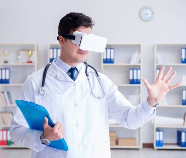 Sanal gerçeklik kulaklığı olan genç doktor ofiste çalışıyor.