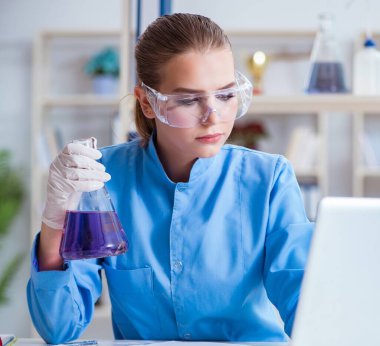 Bir laboratuarda deney yapan kadın bir bilim adamı.