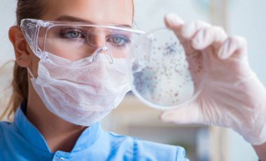 Bir laboratuarda deney yapan kadın bir bilim adamı.