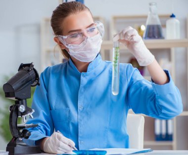 Bir laboratuarda deney yapan kadın bir bilim adamı.