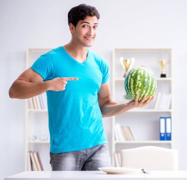 Evde karpuz yiyen bir adam.