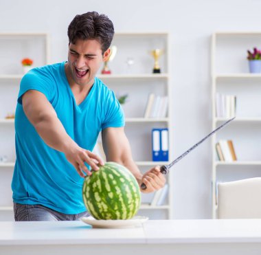 Evde karpuz yiyen bir adam.