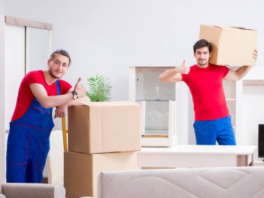 İki müteahhit personel kişisel eşyalarını taşıyor.