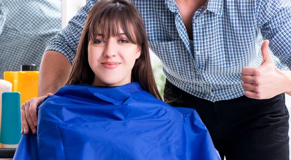 Man male hairdresser doing haircut for woman