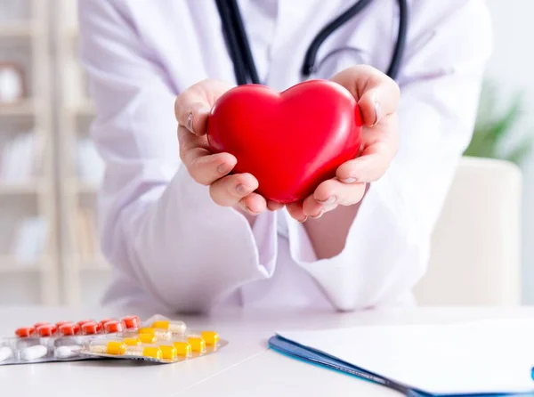 Medico cardiologo con cuore rosso in ospedale — Foto Stock