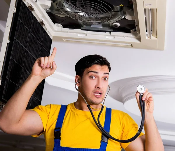 Repairman repairing ceiling air conditioning unit — Stock Photo, Image