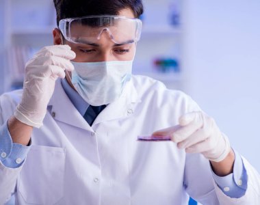 Laboratuvar asistanı hastanede kan örneklerini test ediyor.