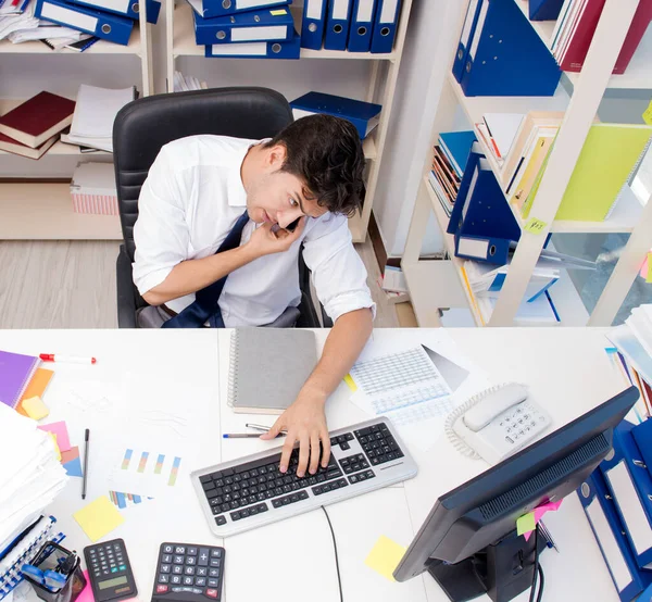 Empresario trabajando en la oficina con montones de libros y papeles — Foto de Stock