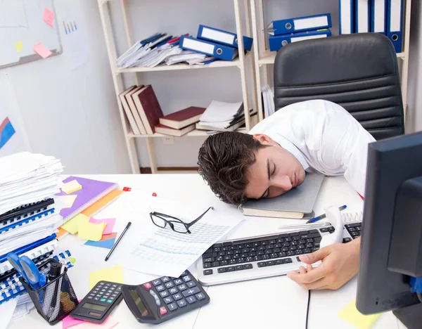 Uomo d'affari che lavora in ufficio con mucchi di libri e carte — Foto Stock