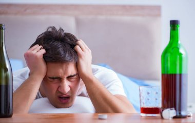 Yatakta içen alkolik adam depresyona giriyor.