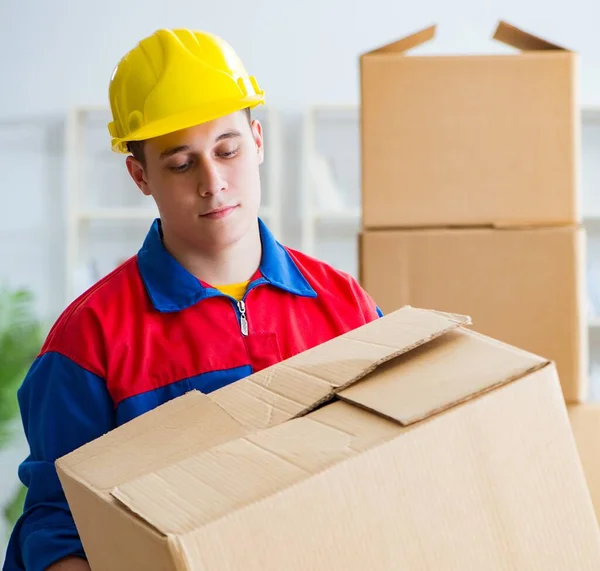 Der junge Mann, der im Umzugsdienst mit Kisten arbeitet — Stockfoto