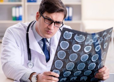 Genç doktor klinikteki röntgen görüntülerine bakıyor.