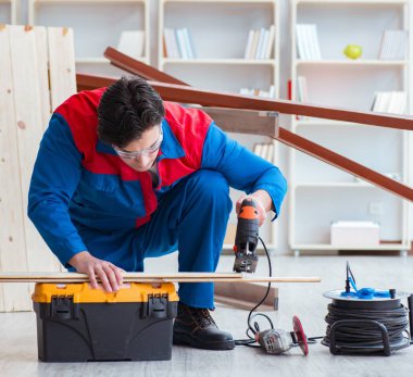 Genç marangoz ahşap kalaslarla çalışıyor.