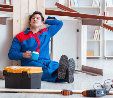 Genç marangoz ahşap kalaslarla çalışmaya ara veriyor.