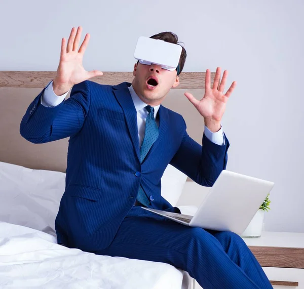 Empresário vestindo um fone de ouvido realidade virtual no quarto — Fotografia de Stock