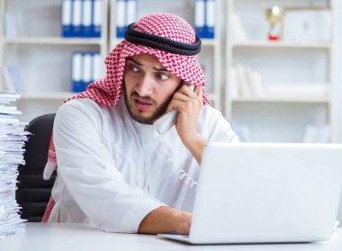 Ofiste çalışan Arap işadamı bir Pi ile evrak işi yapıyor.