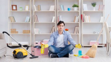 Adam evi temizliyor.