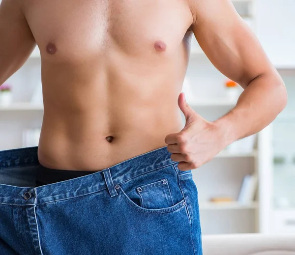 Hombre en pantalones de gran tamaño en concepto de pérdida de peso —  Fotos de Stock