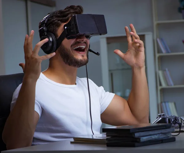 Jovem jogando jogos longas horas atrasado no escritório — Fotografia de Stock