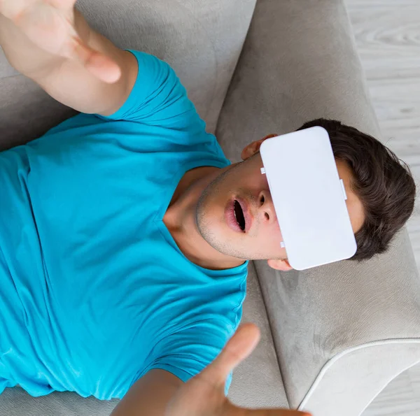 Young man wearing VR glasses relaxing on couch sofa — Stock Photo, Image