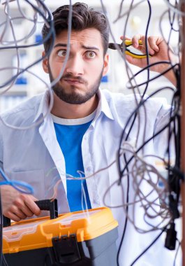 Elektrik teknisyeni tamir konseptinde kabloları çözmeye çalışıyor.