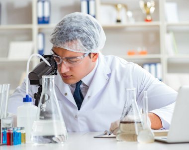 Genç araştırmacı bilim adamı bir su testi kirliliği araştırması yapıyor.