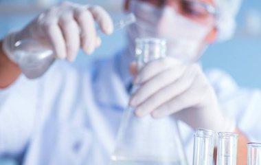 Bir laboratuarda deney yapan kadın bir bilim adamı.