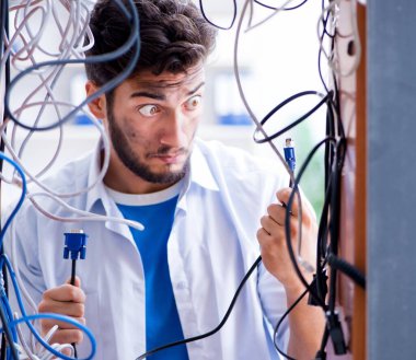 Elektrik teknisyeni tamir konseptinde kabloları çözmeye çalışıyor.