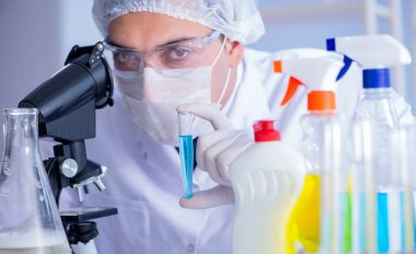 Laboratuvardaki adam yeni temizlik çözeltisi deterjanı test ediyor.