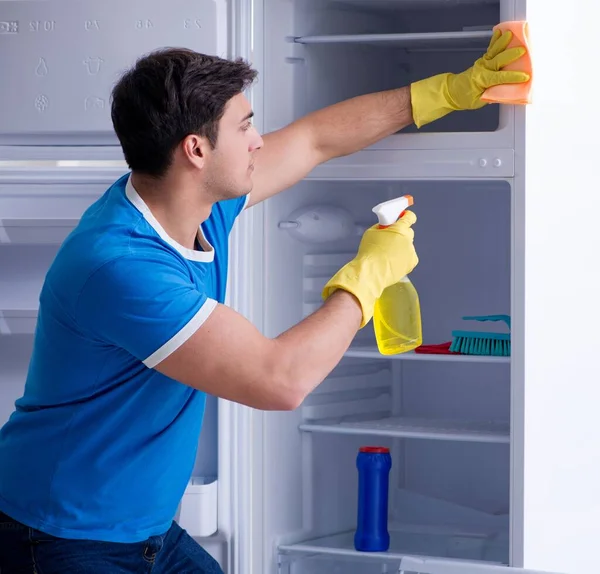Человек чистки холодильника в концепции гигиены — стоковое фото