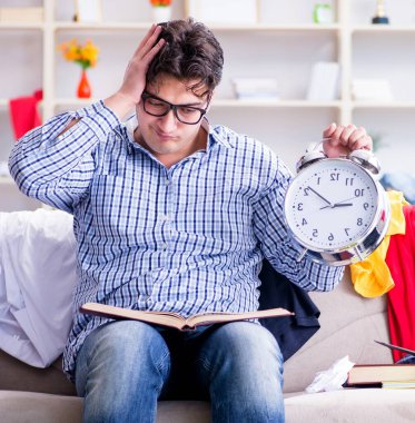 Genç adam dağınık bir odada çalışıyor.