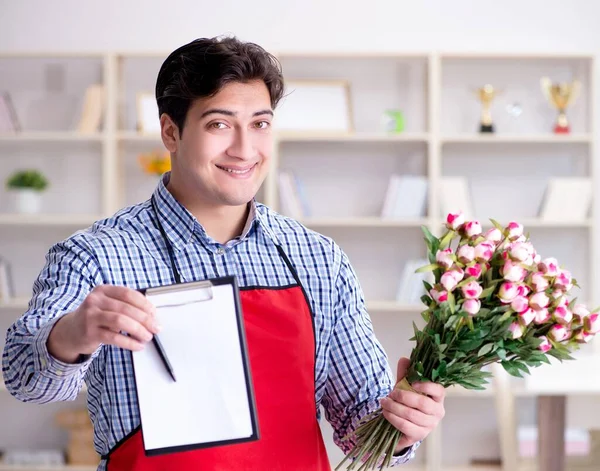 El asistente de la floristería ofreciendo un ramo de flores — Foto de Stock
