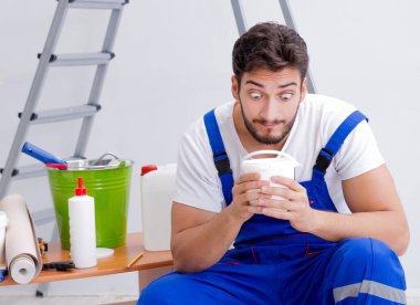 Tamirci, duvar kağıdıyla evde tadilat yapıyor.