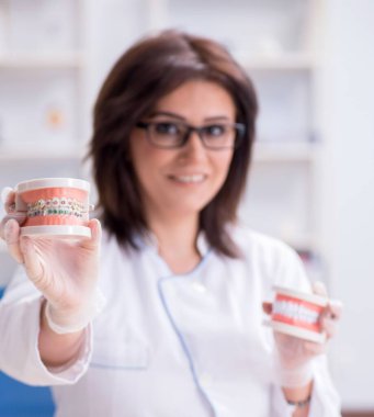 Diş implantı üzerinde çalışan kadın dişçi.