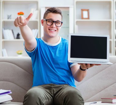 Sınavlara hazırlanan genç öğrenci kanepede ders çalışıyor.