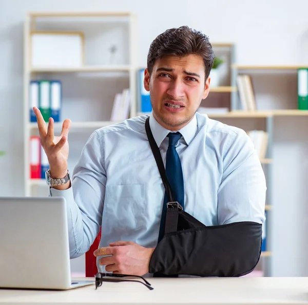 Businessman with broken arm working in office — Stock Photo, Image