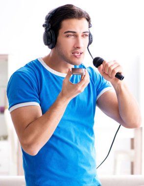 Evde karaoke söyleyen genç adam