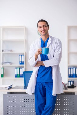 Klinikte çalışan genç erkek doktor.