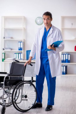 Klinikte çalışan genç erkek doktor.