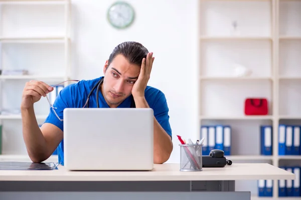 Jonge mannelijke arts werkzaam in de kliniek — Stockfoto