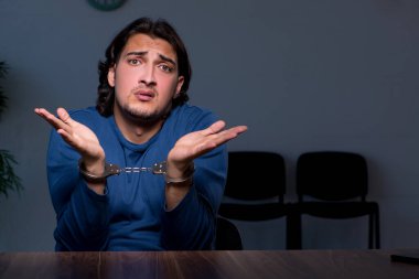 Genç mahkum karanlık odada oturuyor.