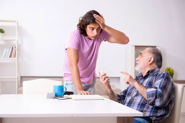 Jonge student en zijn oude opa thuis — Stockfoto