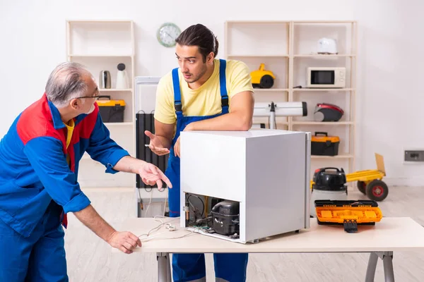 Deux entrepreneurs réparent le réfrigérateur à l'atelier — Photo