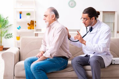 Genç erkek doktor eski hastayı ziyaret ediyor.