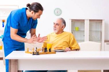 Genç erkek doktor eski hastayı ziyaret ediyor.