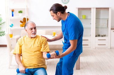 Genç erkek doktor eski hastayı ziyaret ediyor.