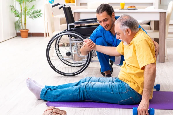 Junger Arzt besucht alte Patientin zu Hause — Stockfoto