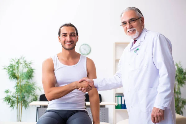 Jovem paciente do sexo masculino visitando médico experiente — Fotografia de Stock