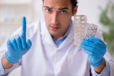 Uyuşturucu sentezi konseptinde genç erkek laboratuvar asistanı