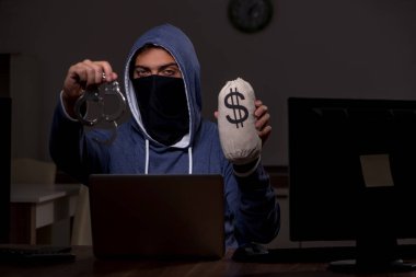 Erkek bilgisayar korsanı, güvenlik duvarını geç saatlerde hackliyor.